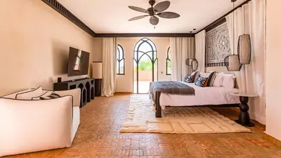 a bedroom with a bed and a ceiling fan at Villa Rehame in Oulad Jellal