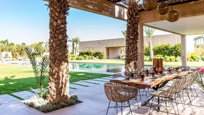 a table and chairs under a pavilion next to a pool at Villa Olfa in Oulad Ikhia
