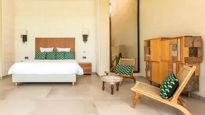 a bedroom with a bed and two chairs at Villa Olfa in Oulad Ikhia