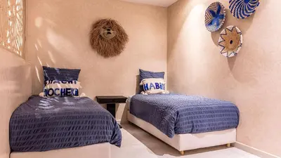 a bedroom with two beds with blue comforters at Villa Olfa in Oulad Ikhia