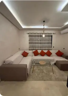 a living room with a large couch and red pillows at Le lux de gueliz in Marrakech