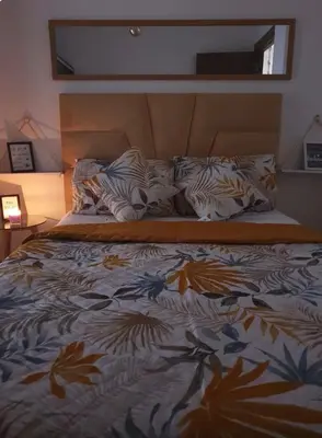 a bed in a bedroom with a bedspread with leaves on it at Le lux de gueliz in Marrakech