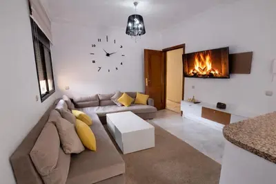 a living room with a couch and a clock on the wall at Elegant cocoon in Guéliz with 2 bedrooms in Marrakech