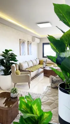a living room with a couch and lots of plants at Marrakech Station Apartment in Marrakech