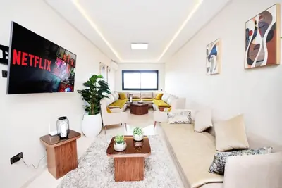 a living room with a couch and a tv at Marrakech Station Apartment in Marrakech