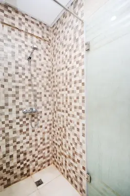 a bathroom with a shower with a tiled wall at Marrakech Station Apartment in Marrakech