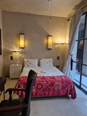 a bedroom with a large bed with a red blanket at RIAD Azur in Marrakech