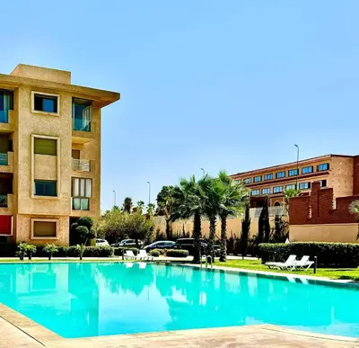 a large swimming pool in front of a building at Noraya Home - Secure residence with pool in Marrakech