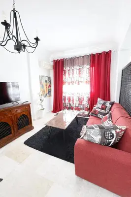 a living room with a red couch and a table at Residence Nadia in Marrakech