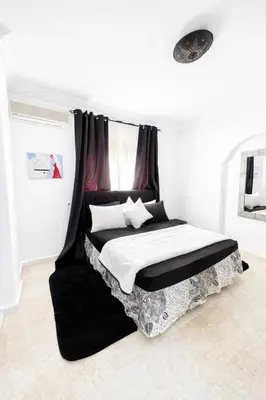 a bedroom with a bed with a black and white canopy at Residence Nadia in Marrakech