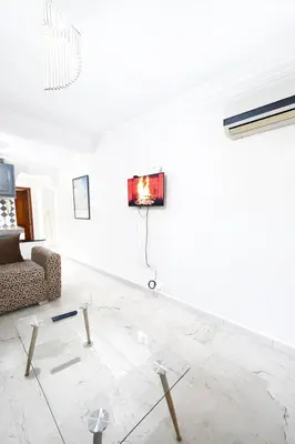 a living room with a couch and a tv on a wall at Residence Nadia in Marrakech