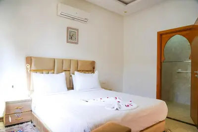 a bedroom with a white bed with flowers on it at فيلال نادية in Marrakech