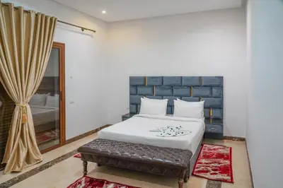 a bedroom with a bed with a bench and a window at فيلال نادية in Marrakech
