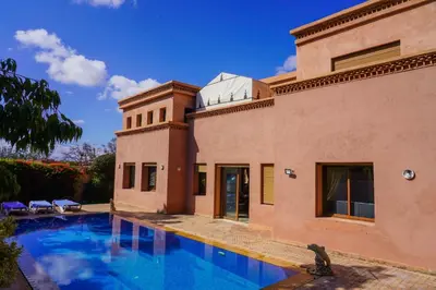 a villa with a swimming pool in front of a building at فيلال نادية in Marrakech