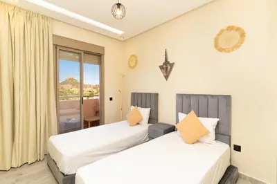 two beds in a room with a window at Elegant Modern Appartement in Gueliz Luxury Touch in Oulad Akkou