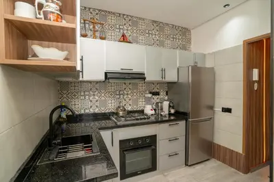 a kitchen with a stove and a refrigerator at Elegant Modern Appartement in Gueliz Luxury Touch in Oulad Akkou