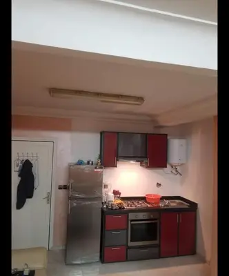 a kitchen with red cabinets and a stainless steel refrigerator at Boston in Marrakech