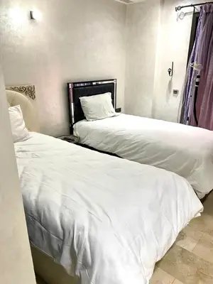 two beds sitting next to each other in a bedroom at Chez Abdou II in Marrakech