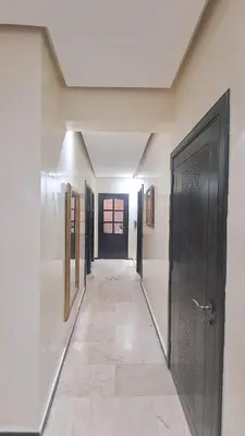 a hallway with a black door and a tile floor at Chez Abdou II in Marrakech