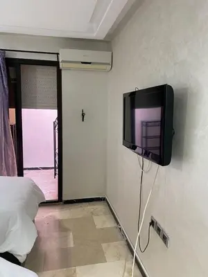 a tv hanging on a wall in a bedroom at Chez Abdou II in Marrakech