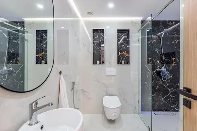 a bathroom with a toilet and a sink and a mirror at Luxury 2-bedroom apartment in Marrakech