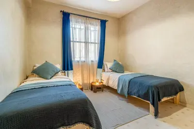 two beds in a room with a window at Beautiful Moroccan 2BR Close to City Center in Marrakech