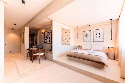 a bedroom with a large bed and a desk at Suite Afra - Cinéma privé & Central in Marrakech