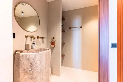 a bathroom with a stone sink and a mirror at Suite Afra - Cinéma privé & Central in Marrakech