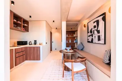 a kitchen and living room with a bench and a table at Suite Afra - Cinéma privé & Central in Marrakech