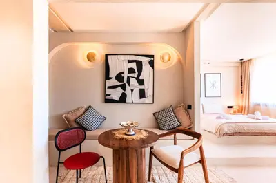 a room with a table and chairs and a bed at Suite Afra - Cinéma privé & Central in Marrakech