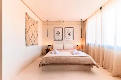 a bedroom with a bed and a large window at Suite Afra - Cinéma privé & Central in Marrakech
