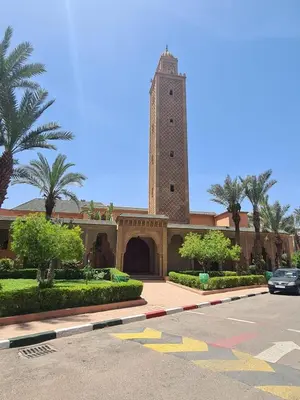 a building with a clock tower in a parking lot at Havre de Paix in Marrakech