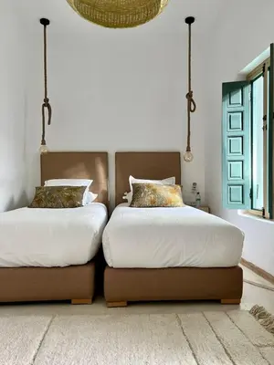 two beds sitting next to each other in a bedroom at Riad Dar Khadra Heritage - Piscine chauffée et Rooftop au cœur de la médina in Marrakech