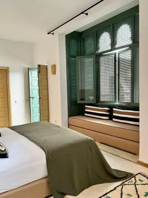 a bedroom with a large bed and a window at Riad Dar Khadra Heritage - Piscine chauffée et Rooftop au cœur de la médina in Marrakech