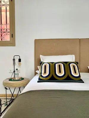 a bedroom with a bed with two pillows on it at Riad Dar Khadra Heritage - Piscine chauffée et Rooftop au cœur de la médina in Marrakech