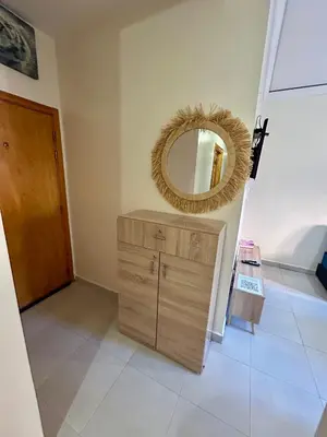 a room with a mirror and a wooden dresser at Appartement 2 chambres à 10mn du centre ville in Marrakech