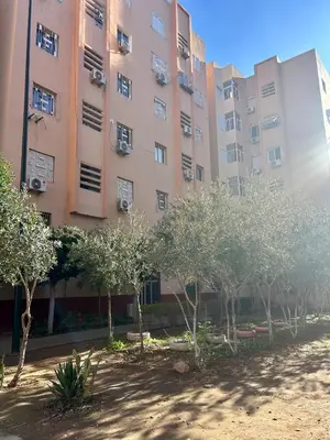 a large building with trees in front of it at Appartement 2 chambres à 10mn du centre ville in Marrakech