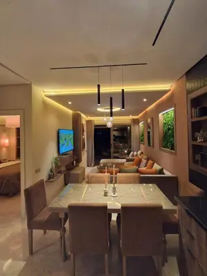 a dining room with a table and a living room at Prestigia Agathe in Marrakech