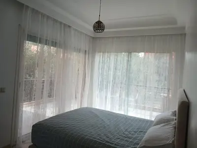 a bedroom with a bed and a large window at Appartement familial - 2 chambres - Hivernage in Marrakech