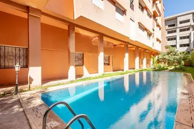 a swimming pool in front of a building at Appartement familial - 2 chambres - Hivernage in Marrakech