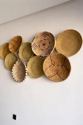 a group of straw hats hanging on a wall at Cozy & Modern Gueliz Apartment in Marrakech