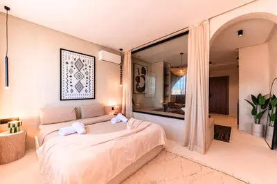 a bedroom with a large bed and a large window at Suite Tifawt - Central, Design & Lumineux in Marrakech