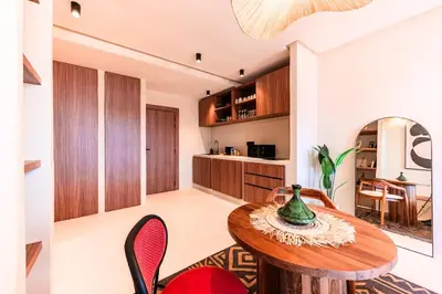a kitchen and dining room with a wooden table and chairs at Suite Tifawt - Central, Design & Lumineux in Marrakech