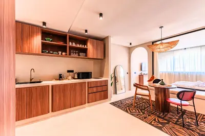 a kitchen with wooden cabinets and a table and chairs at Suite Tifawt - Central, Design & Lumineux in Marrakech