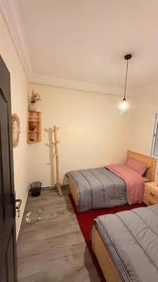 a bedroom with two beds and a cross on the wall at Your Hidden Oasis, Quiet, Cozy and Charming in Marrakech