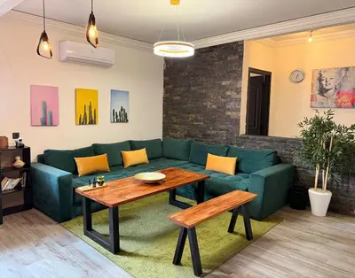 a living room with a green couch and a table at Your Hidden Oasis, Quiet, Cozy and Charming in Marrakech