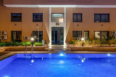 a swimming pool in front of a building at night at Moonlight Suite Pool and Relaxation in Marrakech