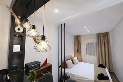 a bedroom with a bed and two lights at Studio sur guiliz avec piscine et parking in Marrakech