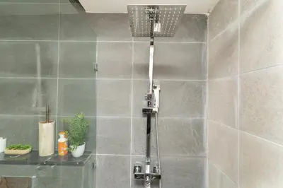 a shower in a bathroom with a tile wall at Home Holiday pool-Guéliz, Marrakech in Marrakech