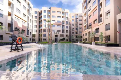 a swimming pool in front of some apartment buildings at Home Holiday pool-Guéliz, Marrakech in Marrakech